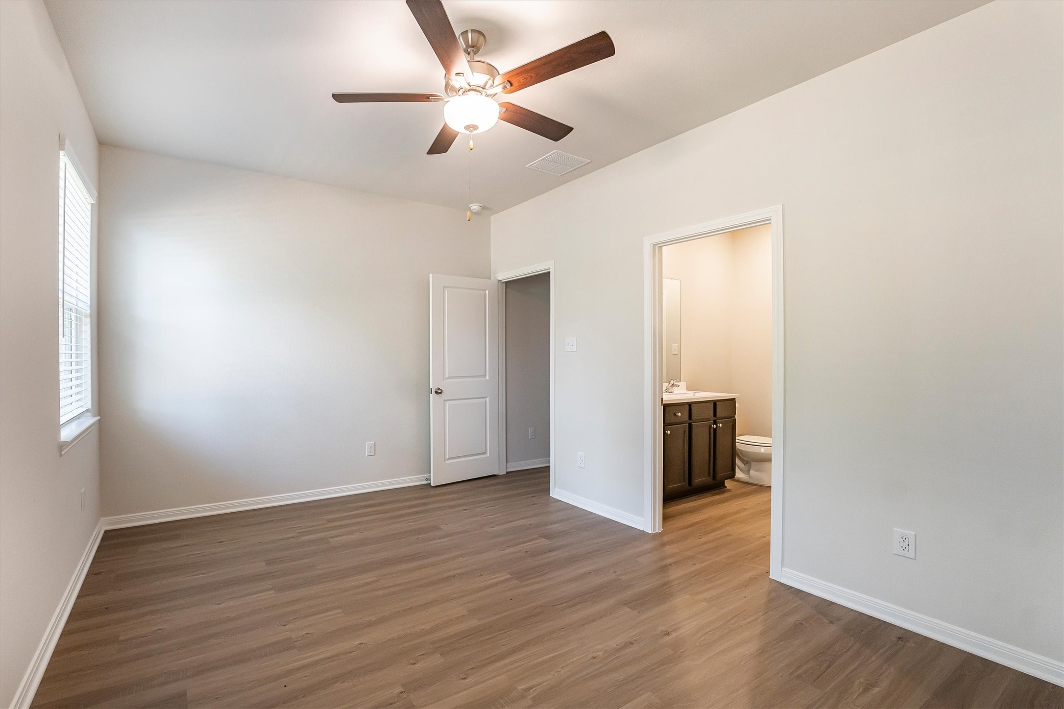 15419 Maple Ter Drive Conroe, TX 77303 - Photo 16 of 32 an empty room with wooden floor and windows
