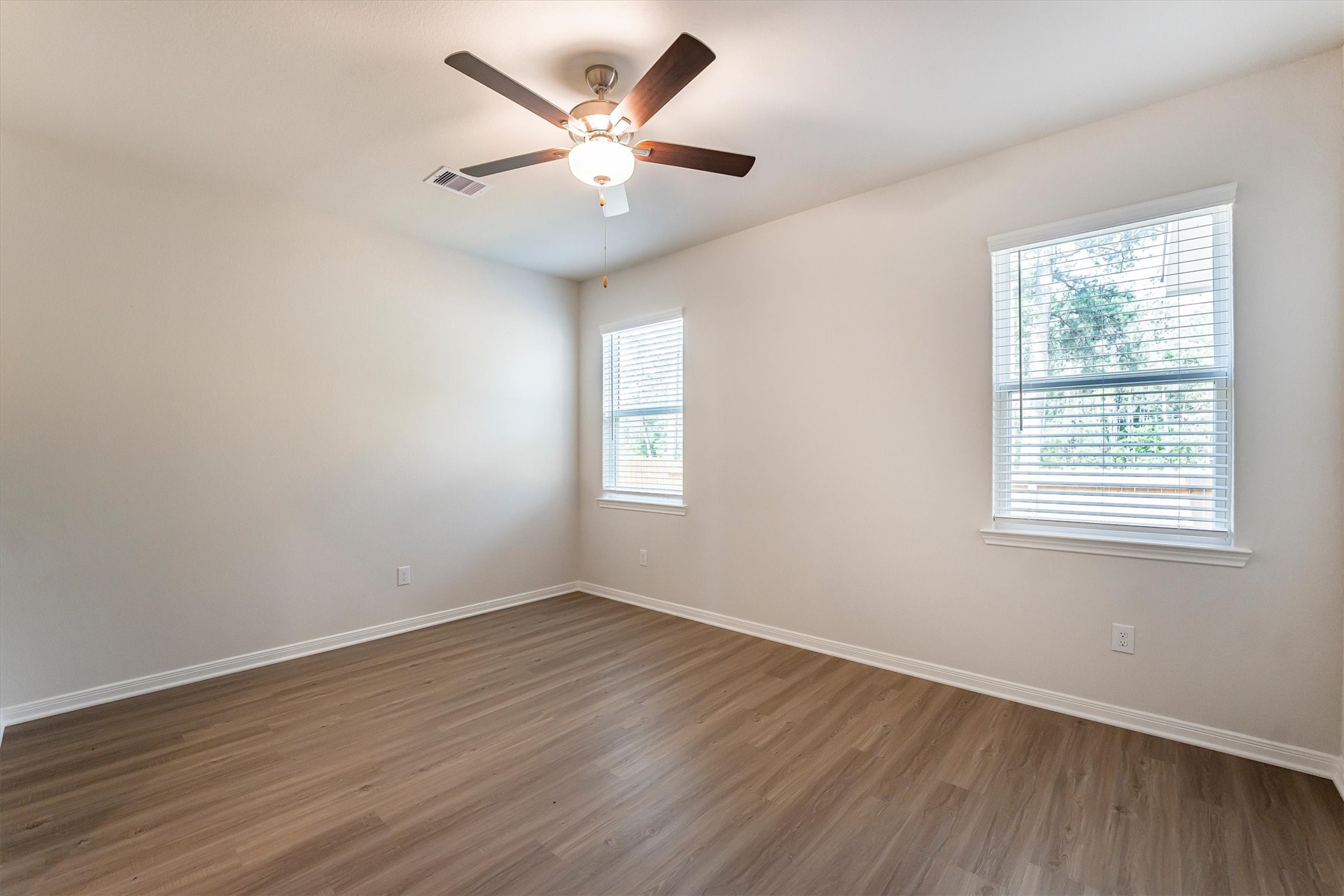 15419 Maple Ter Drive Conroe, TX 77303 - Photo 17 of 32 an empty room with wooden floor and windows