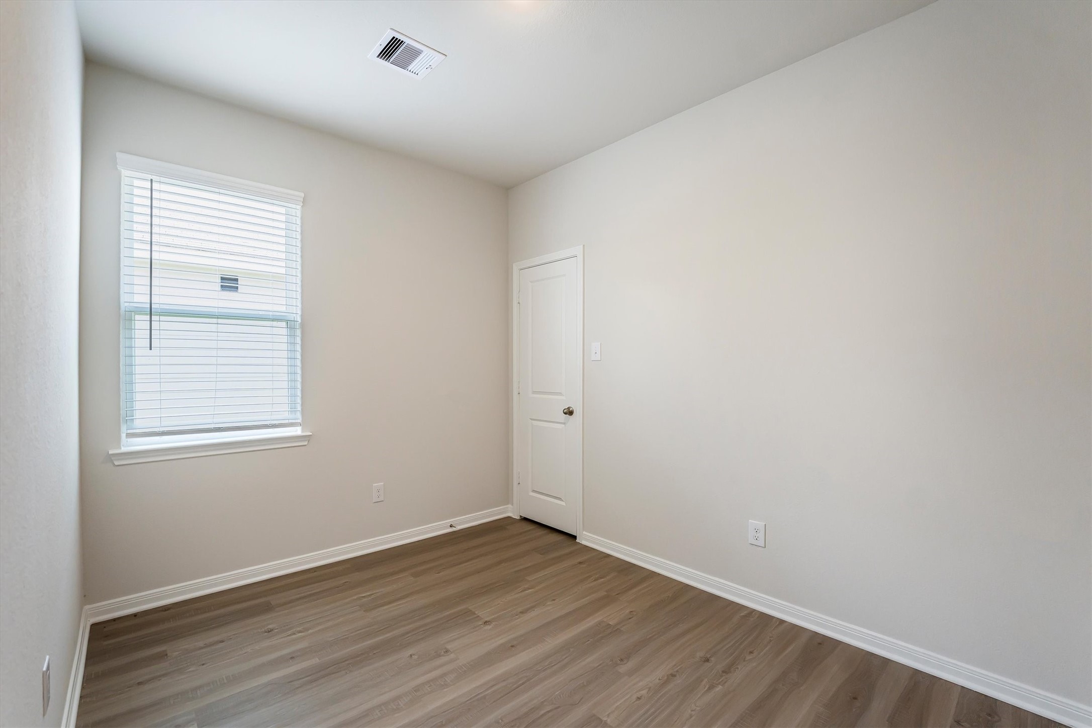 15419 Maple Ter Drive Conroe, TX 77303 - Photo 23 of 32 a view of an empty room with wooden floor and a window