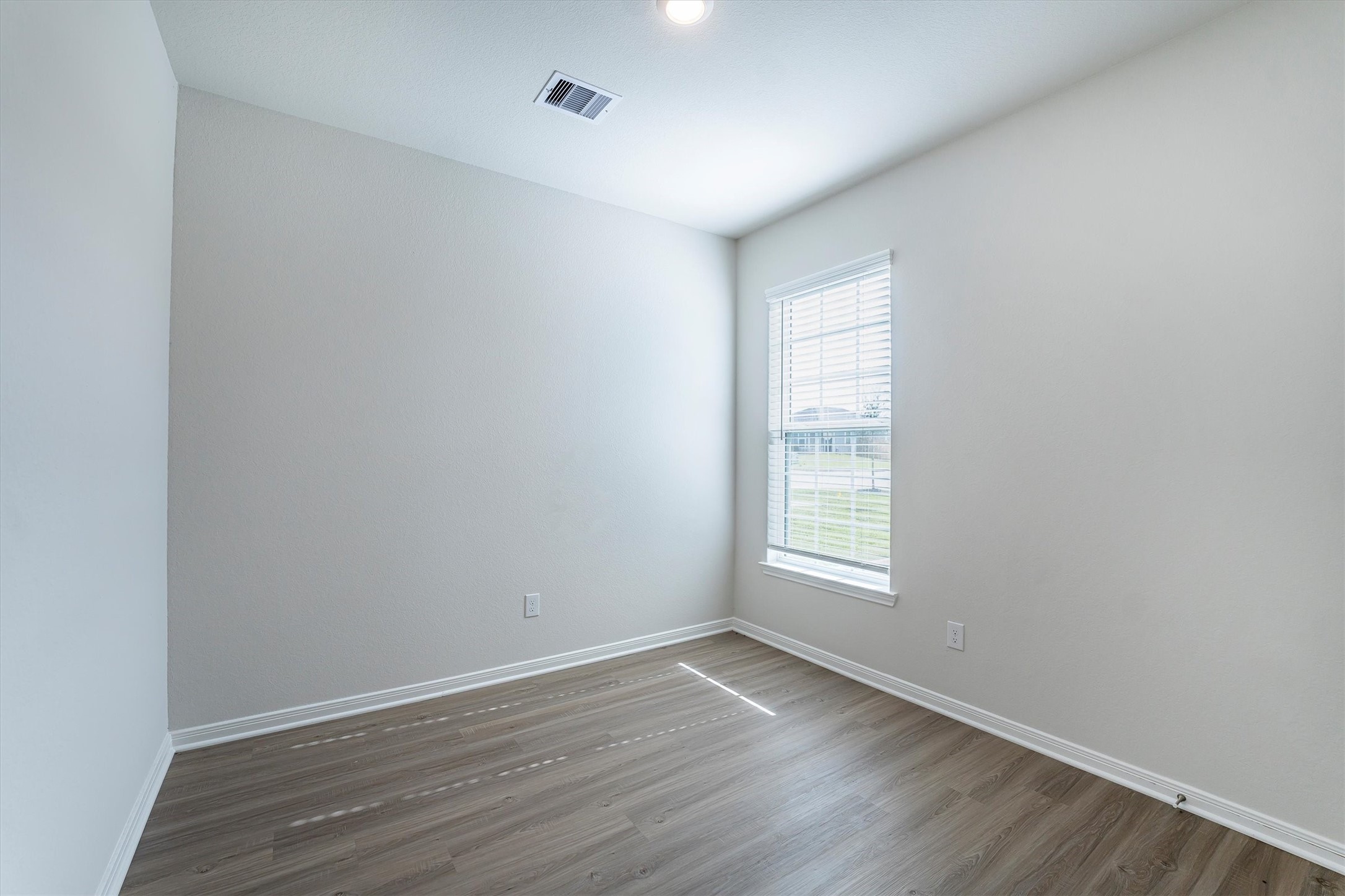15419 Maple Ter Drive Conroe, TX 77303 - Photo 26 of 32 an empty room with wooden floor and windows