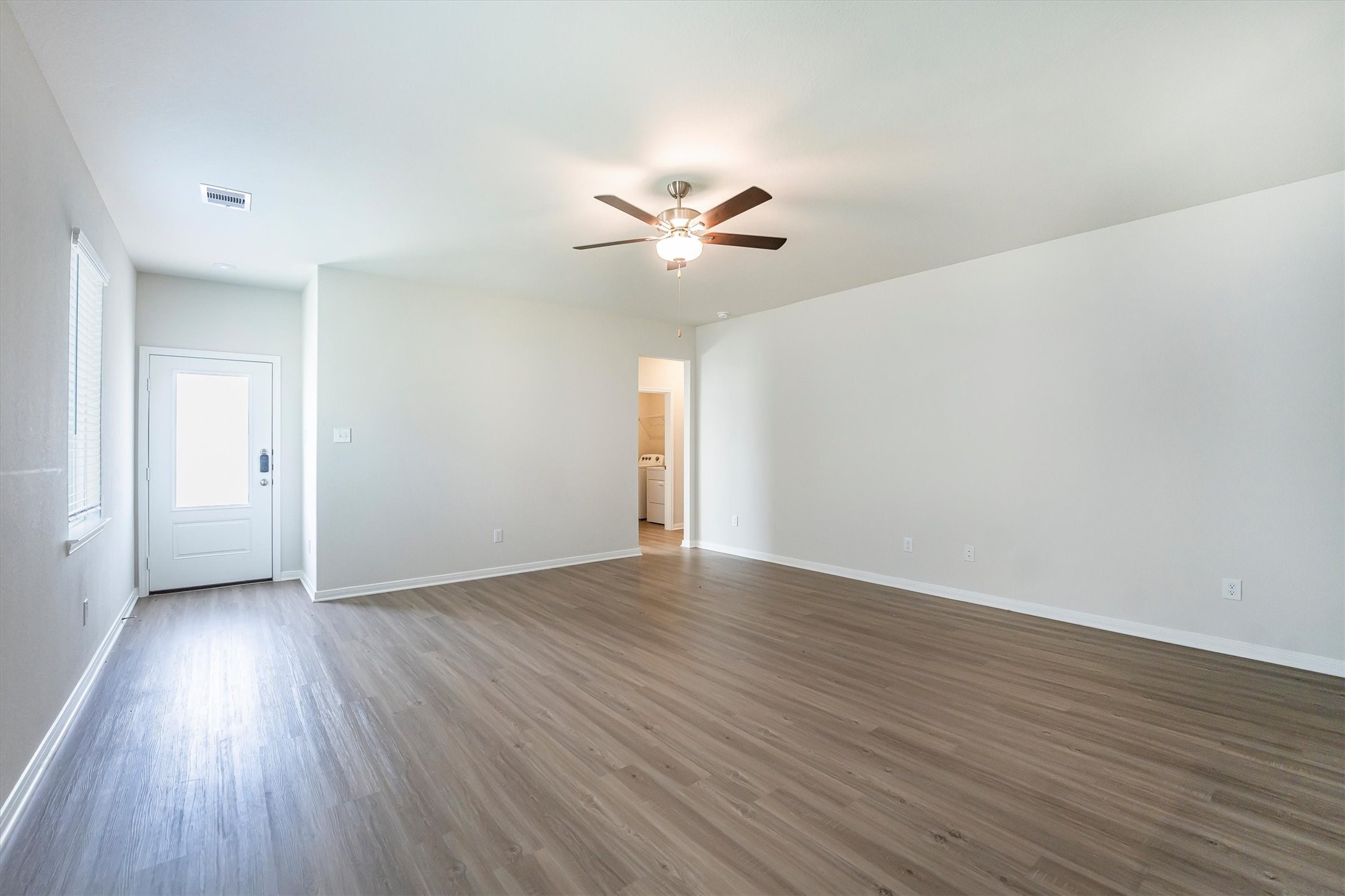 15419 Maple Ter Drive Conroe, TX 77303 - Photo 6 of 32 an empty room with wooden floor and a ceiling fan
