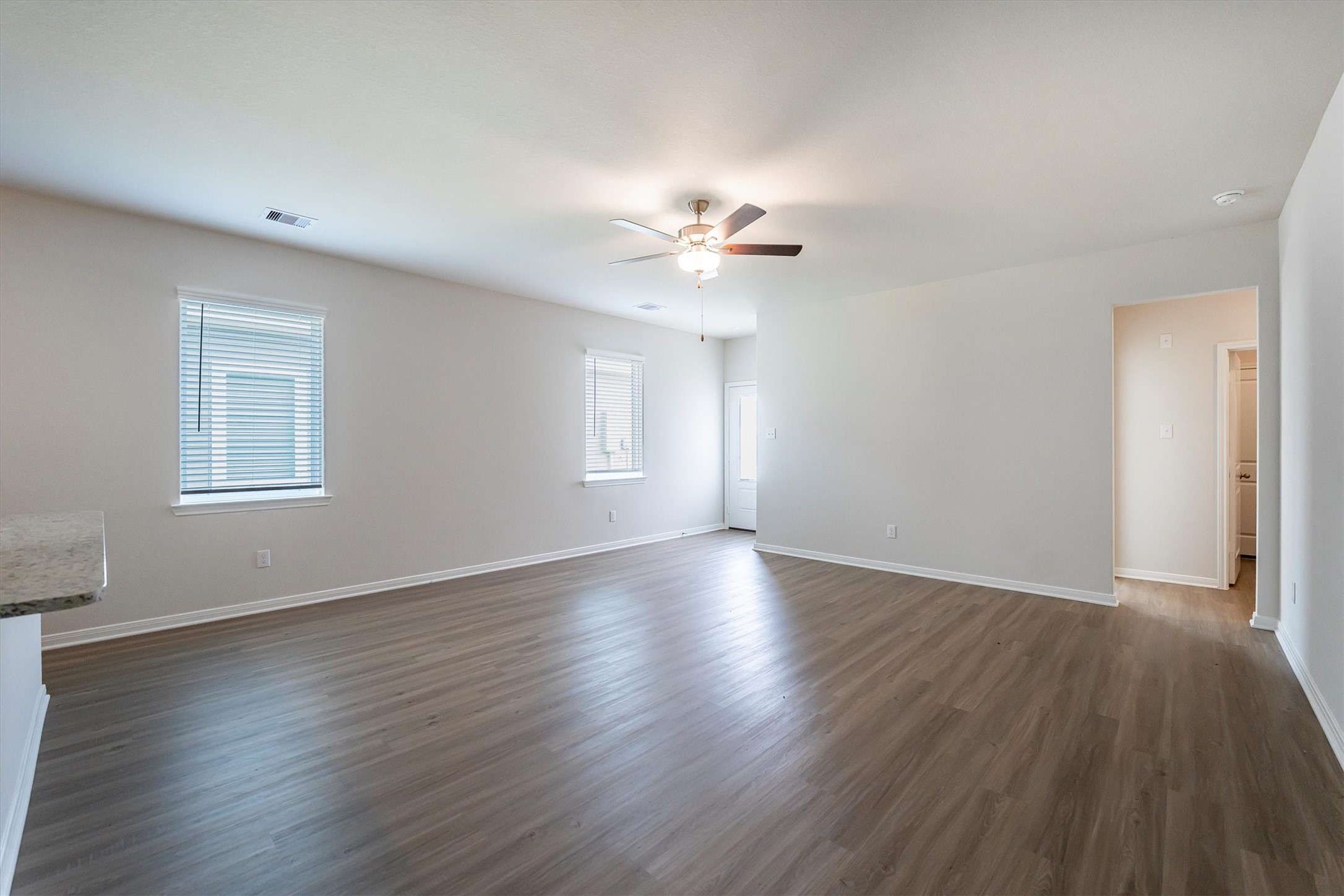 15419 Maple Ter Drive Conroe, TX 77303 - Photo 7 of 32 a view of an empty room with a window and wooden floor
