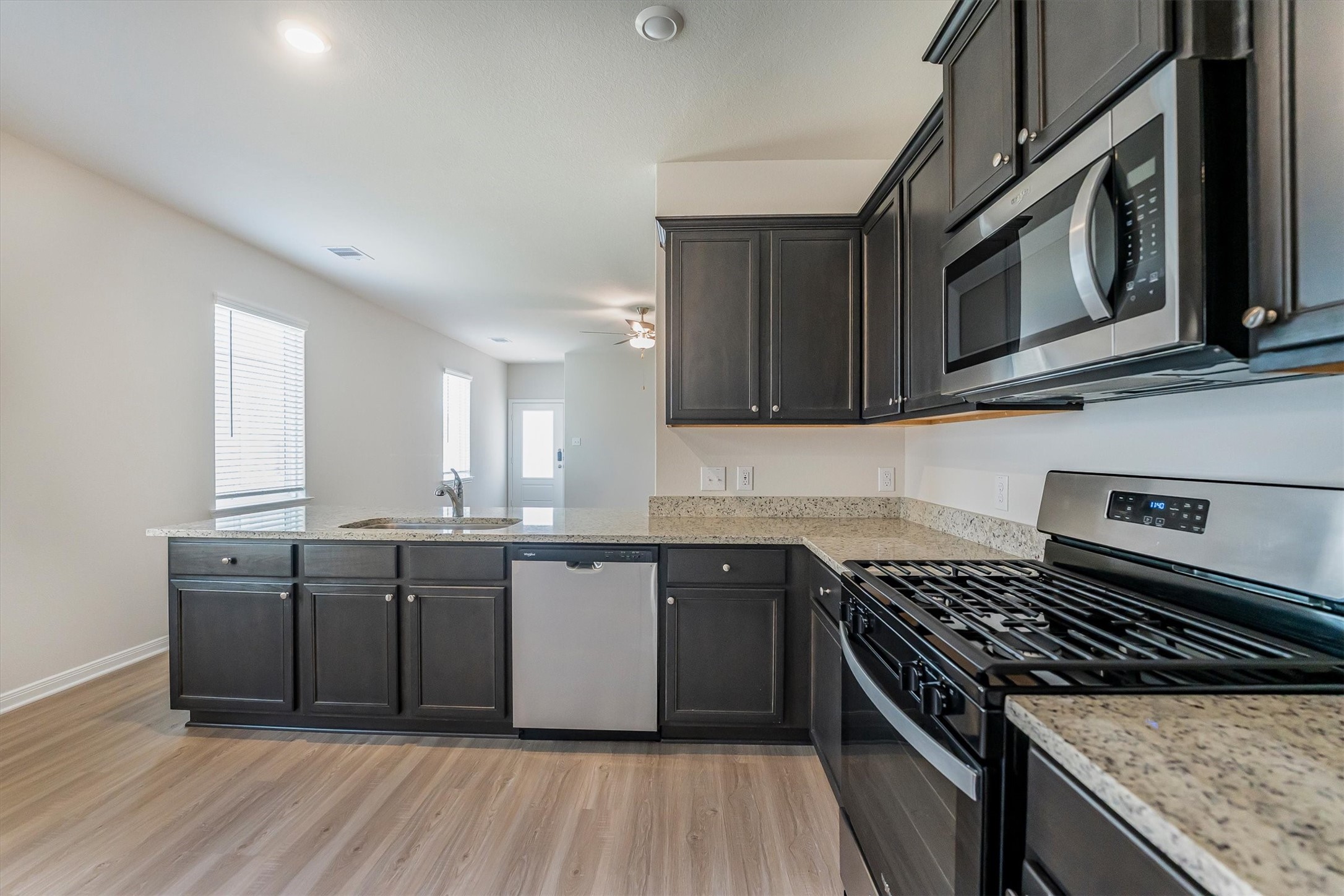 15419 Maple Ter Drive Conroe, TX 77303 - Photo 9 of 32 a kitchen with stainless steel appliances granite countertop a stove a sink and a microwave