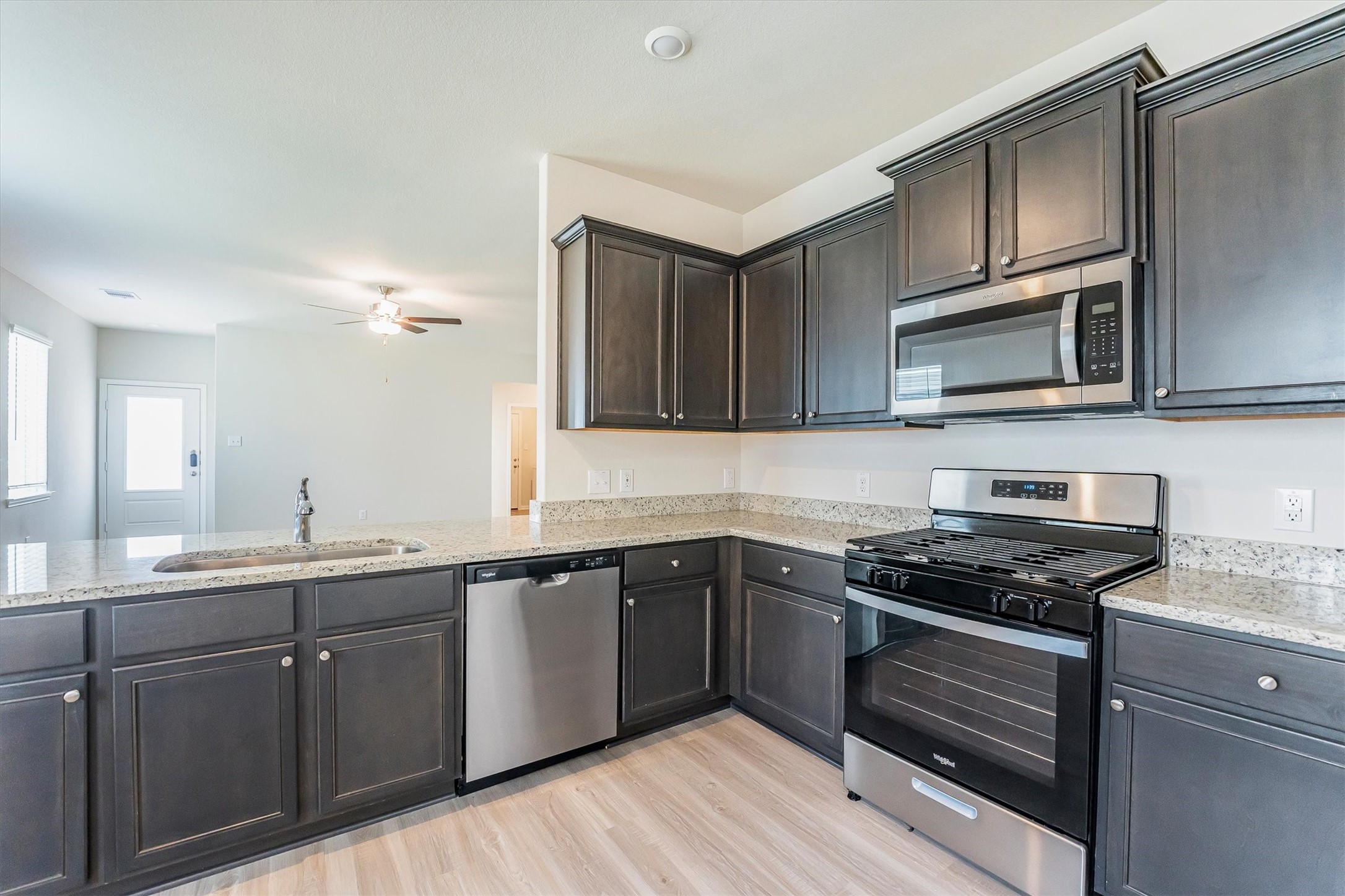 15419 Maple Ter Drive Conroe, TX 77303 - Photo 10 of 32 a kitchen with stainless steel appliances a stove sink microwave and cabinets