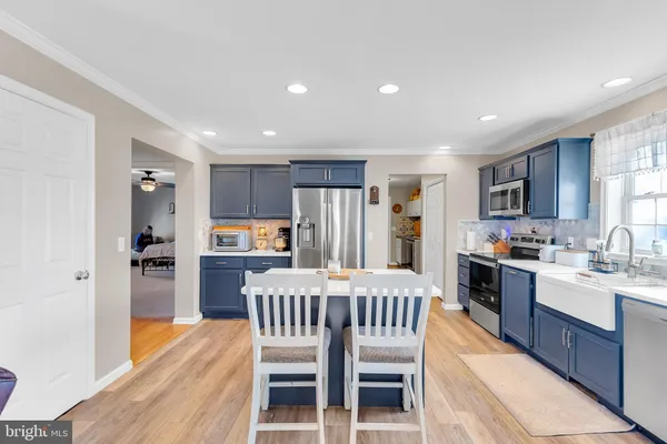 a kitchen with refrigerator a sink and chairs