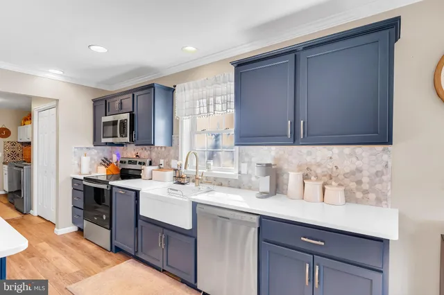 a kitchen with a sink a stove and cabinets