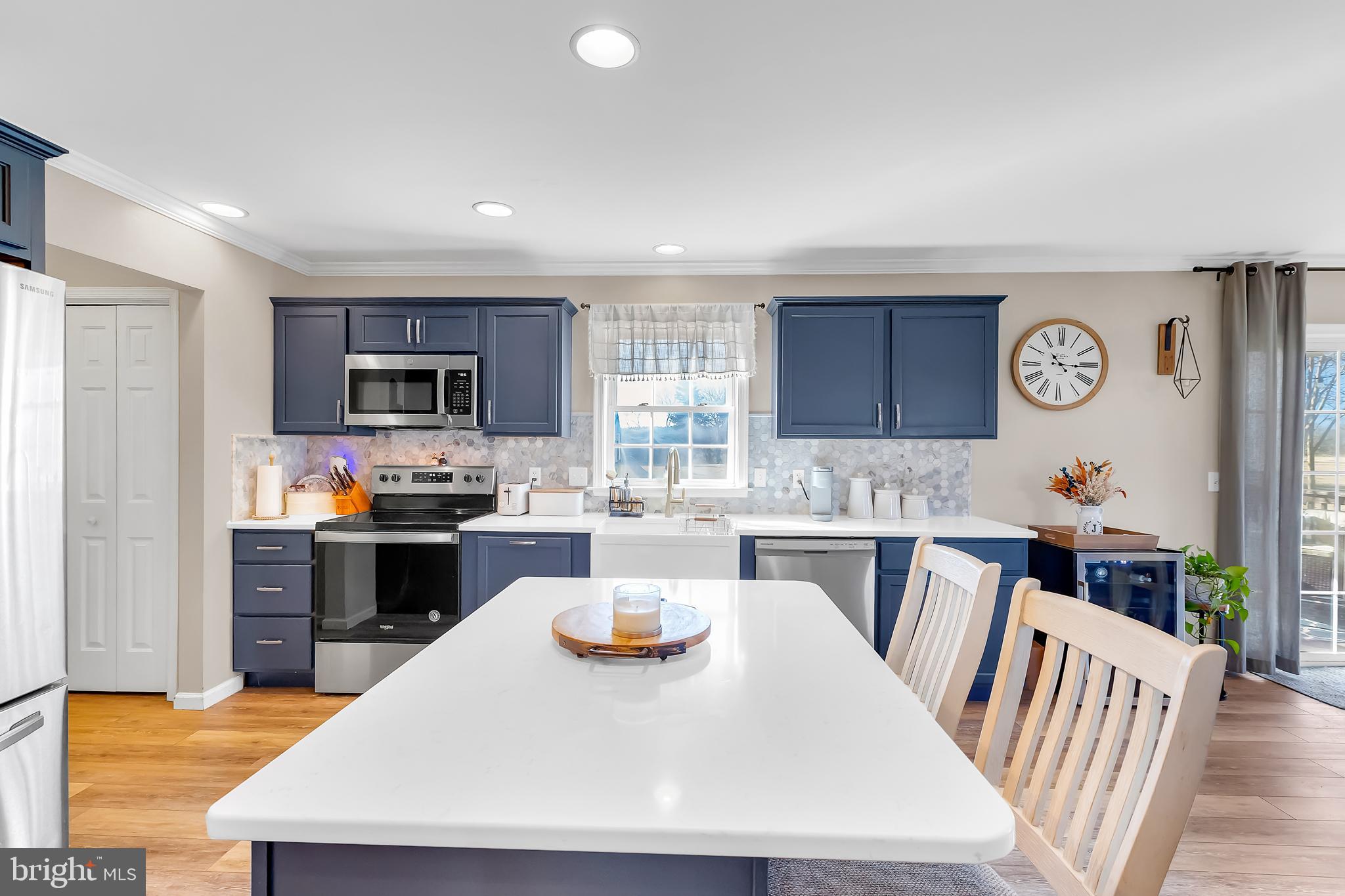 8960 Bacons Road Delmar, DE 19940 - Photo 19 of 51 a kitchen with a refrigerator a stove top oven a sink dishwasher and white cabinets with wooden floor