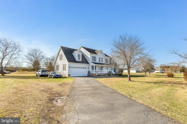 a view of a swimming pool and trees in front of house