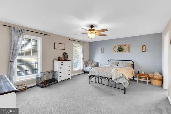 a spacious bedroom with a bed and a chandelier