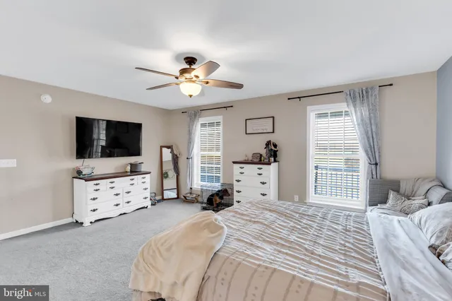 a spacious bedroom with a bed and a flat screen tv