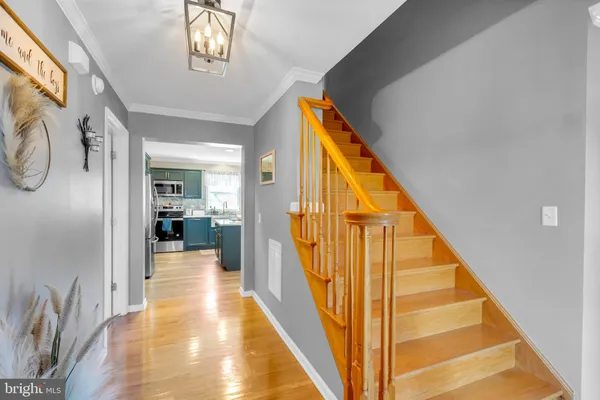 a view of a hallway with wooden floor and staircase