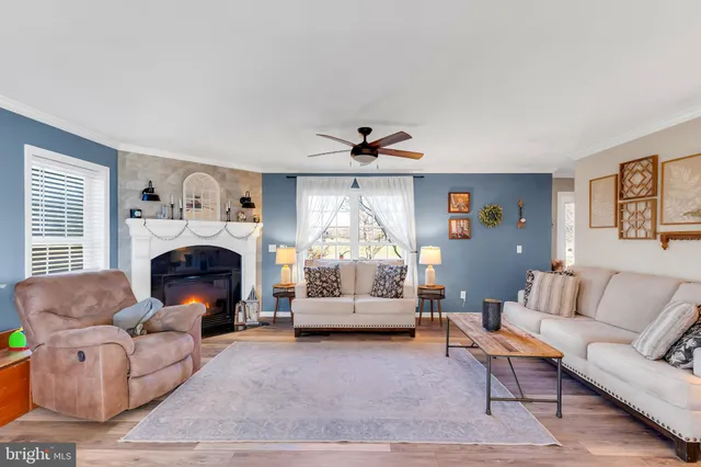 a living room with furniture a fireplace and a large window
