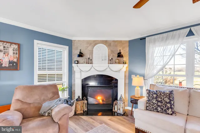 a living room with furniture a fireplace and a large window
