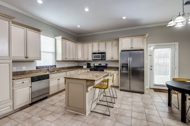 a kitchen with stainless steel appliances granite countertop a stove a sink a refrigerator a microwave and cabinets