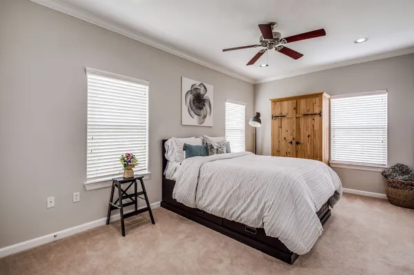 a bedroom with a bed a window and a ceiling fan