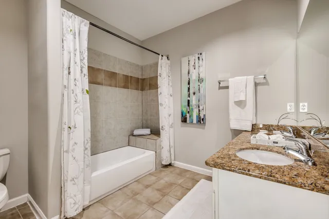 a bathroom with a granite countertop sink and a mirror a bathtub