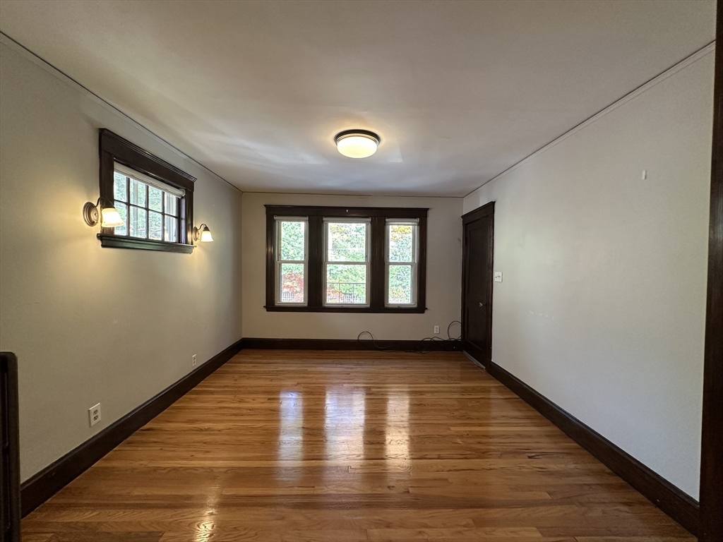 77 Walk Hill Street, Unit 1 Boston, MA 02130 - Photo 1 of 29 a view of an empty room with wooden floor and a window