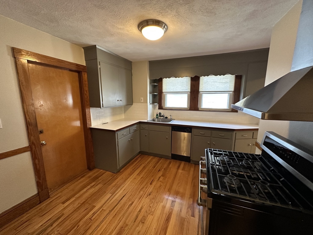 77 Walk Hill Street, Unit 1 Boston, MA 02130 - Photo 11 of 29 a kitchen with granite countertop a stove and a refrigerator