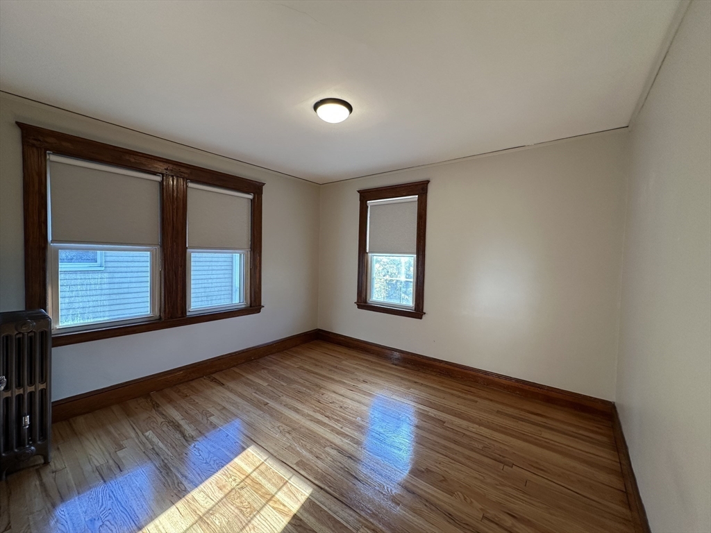 77 Walk Hill Street, Unit 1 Boston, MA 02130 - Photo 19 of 29 a view of an empty room with wooden floor and a window