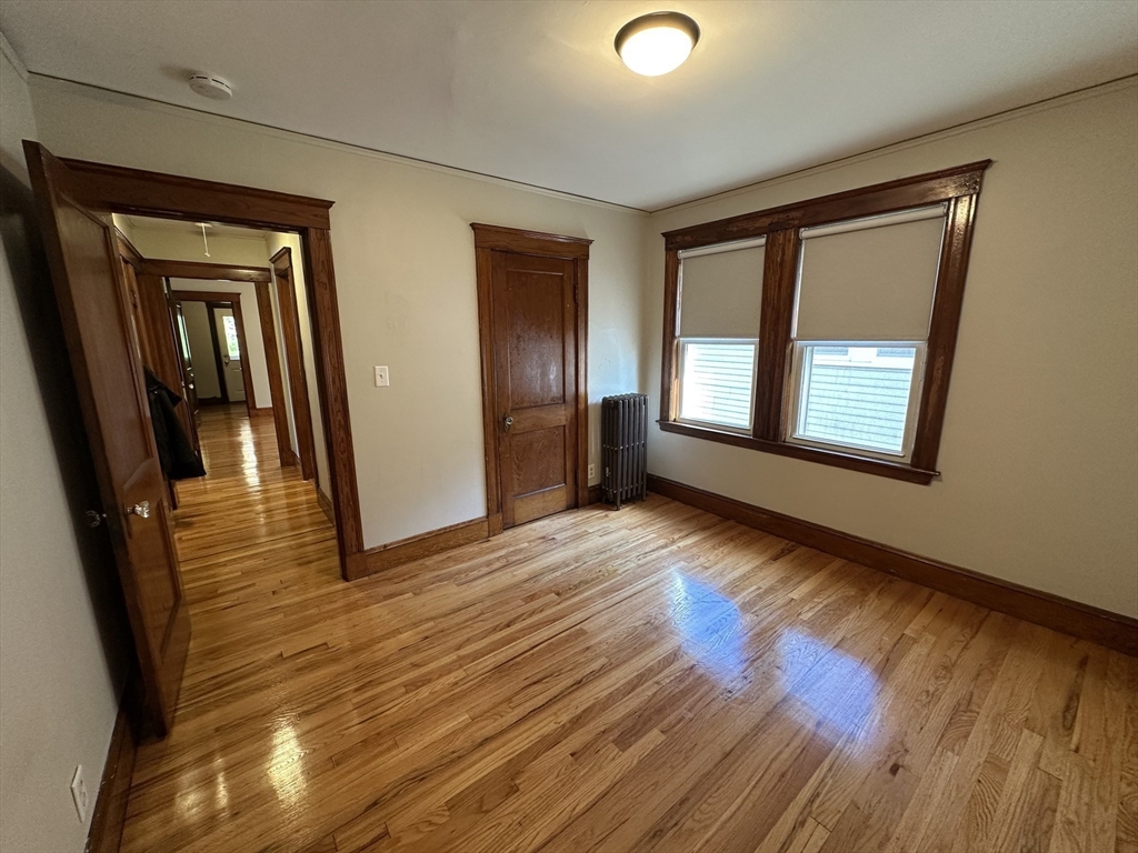 77 Walk Hill Street, Unit 1 Boston, MA 02130 - Photo 20 of 29 a view of an empty room with wooden floor and a window