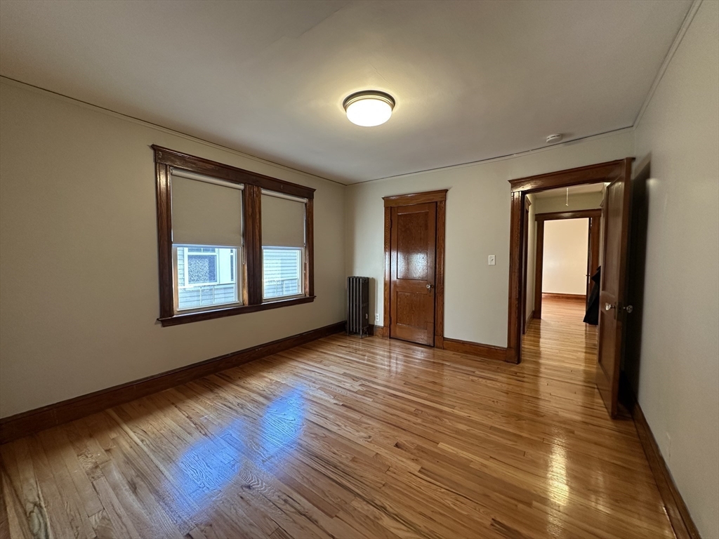 77 Walk Hill Street, Unit 1 Boston, MA 02130 - Photo 7 of 29 an empty room with wooden floor and windows