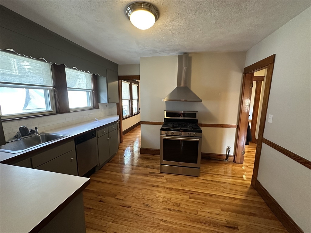 77 Walk Hill Street, Unit 1 Boston, MA 02130 - Photo 9 of 29 a kitchen with stainless steel appliances a stove a sink and a refrigerator