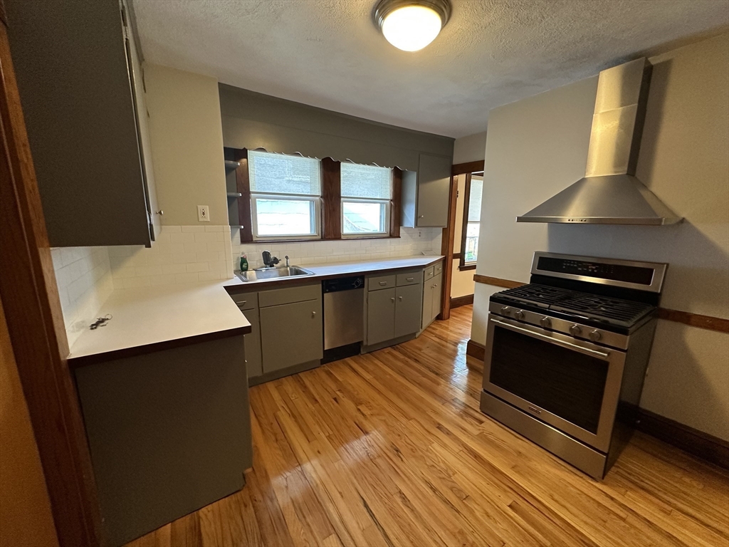 77 Walk Hill Street, Unit 1 Boston, MA 02130 - Photo 10 of 29 a kitchen with stainless steel appliances a sink cabinets and wooden floor