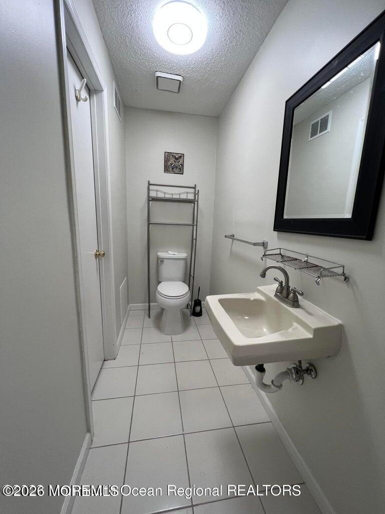 12-7 Phoenix Court Freehold, NJ 07728 - Photo 12 of 12 a bathroom with a sink toilet and mirror