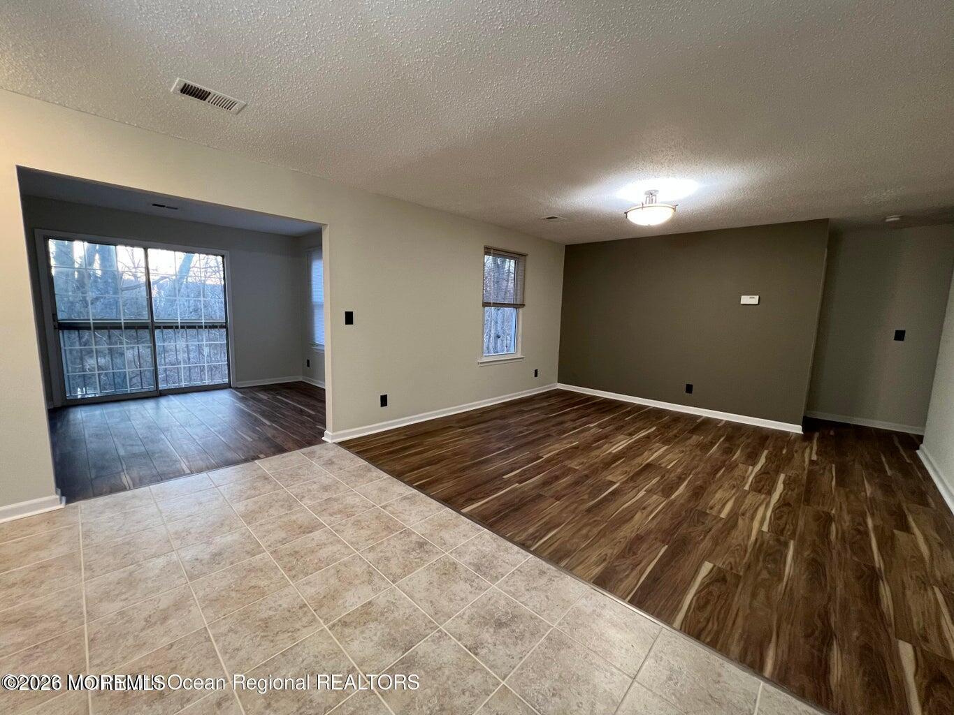 12-7 Phoenix Court Freehold, NJ 07728 - Photo 2 of 12 wooden floor in an empty room with a window