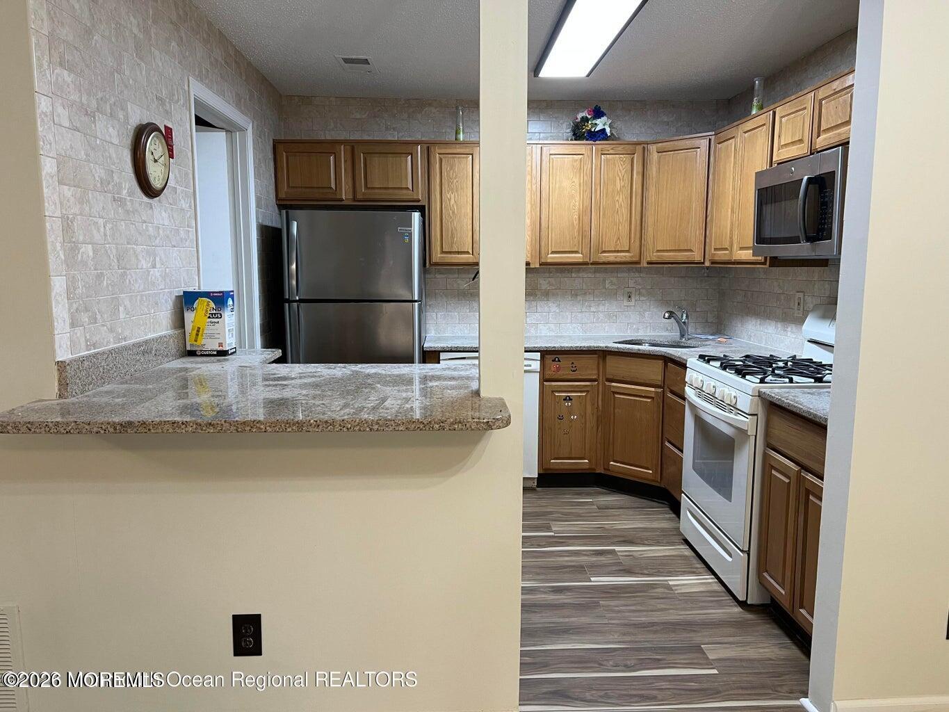 12-7 Phoenix Court Freehold, NJ 07728 - Photo 8 of 12 a kitchen with a sink a stove and refrigerator