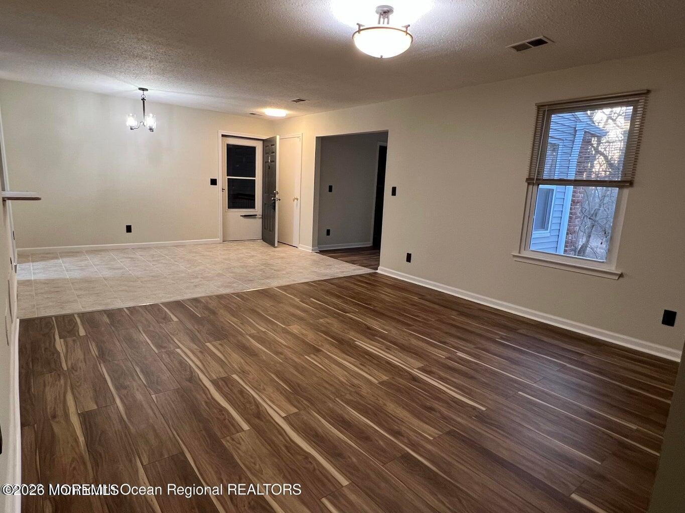 12-7 Phoenix Court Freehold, NJ 07728 - Photo 10 of 12 an empty room with wooden floor and windows