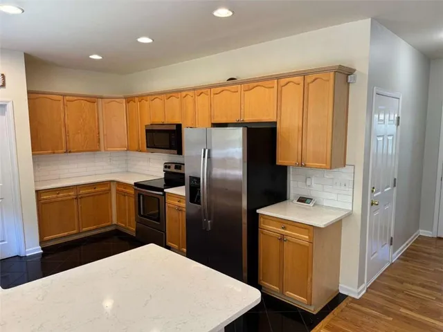 a kitchen with a refrigerator sink and cabinets