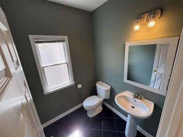 a bathroom with a toilet sink and a mirror
