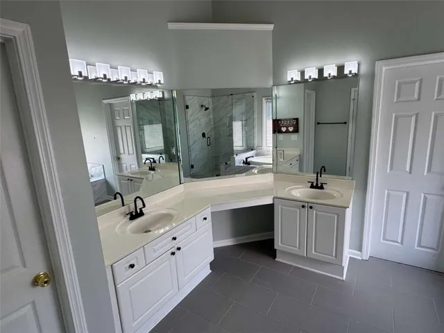 a bathroom with double vanity sink and a mirror