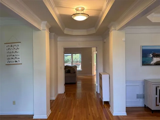 a view of a hallway with wooden floor and staircase