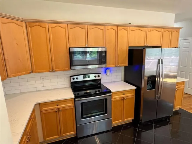 a kitchen with stainless steel appliances a stove a microwave and a refrigerator