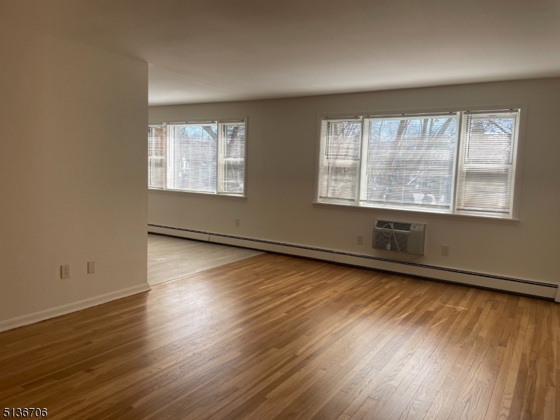 948 Valley Road, Unit A7 Clifton, NJ 07013 - Photo 2 of 9 an empty room with wooden floor and windows