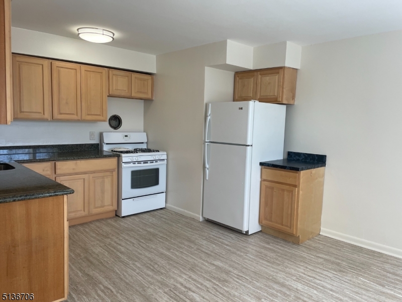 948 Valley Road, Unit A7 Clifton, NJ 07013 - Photo 4 of 9 a kitchen with a refrigerator sink and cabinets