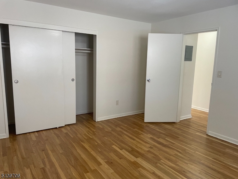 948 Valley Road, Unit A7 Clifton, NJ 07013 - Photo 7 of 9 a view of an empty room with wooden floor and closet