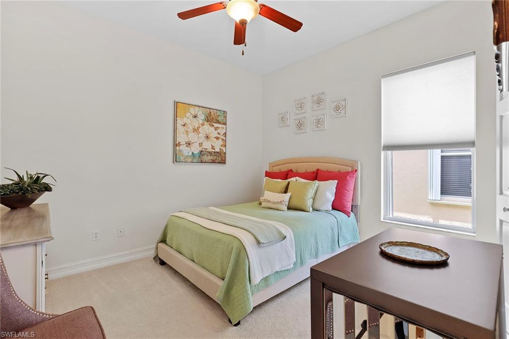 6769 Bent Grass Drive Naples, FL 34113 - Photo 15 of 32 a bedroom with a bed and a workspace