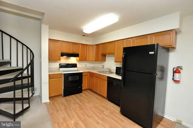 a kitchen with granite countertop a refrigerator stove top oven and sink