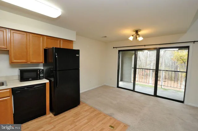 a view of an empty room with a kitchen