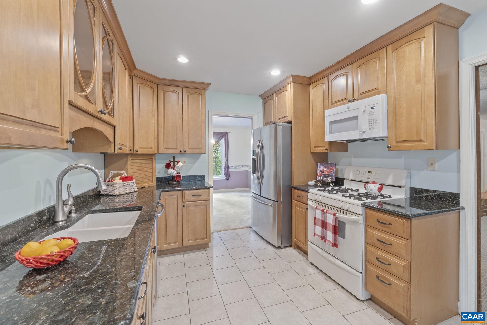 1211 Lanetown Road Crozet, VA 22932 - Photo 16 of 50 a kitchen with stainless steel appliances granite countertop a stove a sink dishwasher and a refrigerator with wooden cabinets