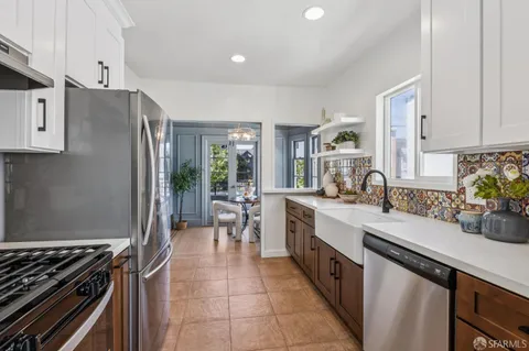 a large kitchen with a large window and stainless steel appliances