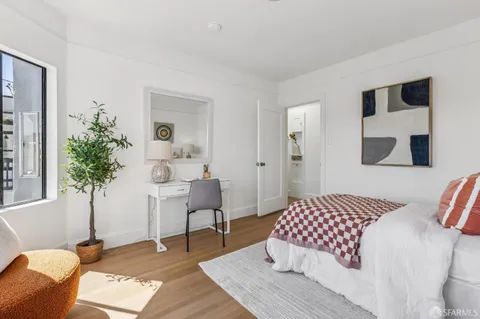 a bedroom with a bed and a potted plant on table