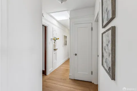 a view of a hallway with wooden floor