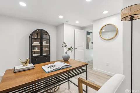a kitchen with white cabinets and sink