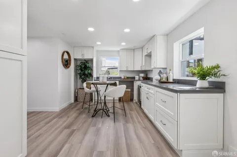 a kitchen with a table chairs refrigerator and cabinets