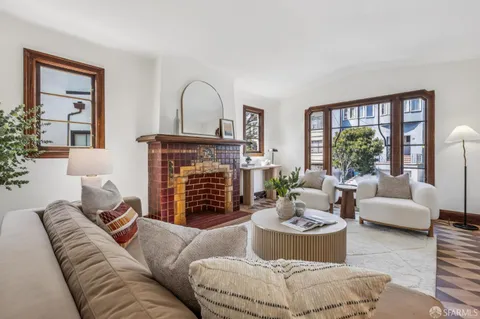 a living room with fireplace furniture and a large window