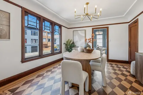 a dining room with furniture a chandelier and window